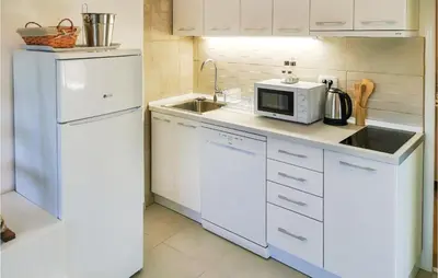 a white kitchen with a sink and a microwave at Awesome Apartment In Utjeha With Wifi in Utjeha