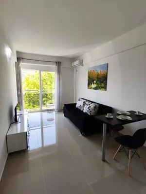 a living room with a black couch and a table at Vi studio city center 2min to sea in Bar