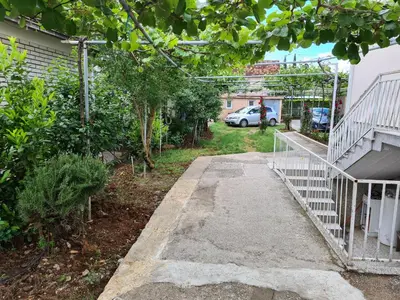 a driveway leading into a yard with a car parked at Apartments F in Podgorica