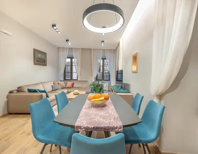a living room with a table and blue chairs at Sasha di Cattaro - Old Town Lux Apartment in Kotor