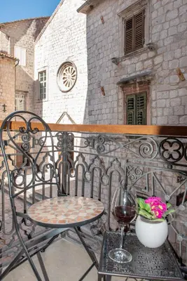 a chair and a glass of wine on a balcony at Sasha di Cattaro - Old Town Lux Apartment in Kotor