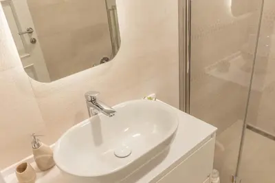 a bathroom with a white sink and a shower at Sasha di Cattaro - Old Town Lux Apartment in Kotor