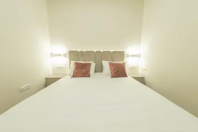 a bedroom with a large white bed with two pillows at Sasha di Cattaro - Old Town Lux Apartment in Kotor
