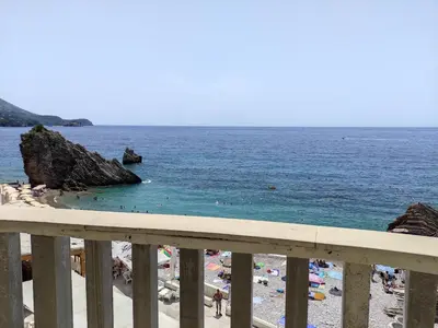a view of a beach with people in the water at Apartments Altea in Rafailovici