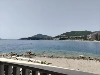 a view of a beach with a fence and the water at Apartments Altea in Rafailovici