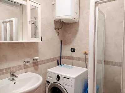 a bathroom with a washing machine and a sink at Apartments Altea in Rafailovici