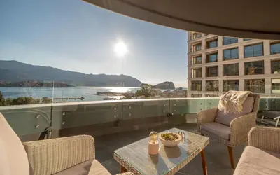 a balcony with a table and chairs and a view of the water at Amare Luxury Apartments in Budva
