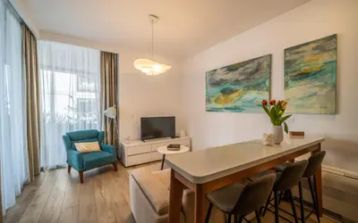 a living room with a table and chairs and a television at Amare Luxury Apartments in Budva