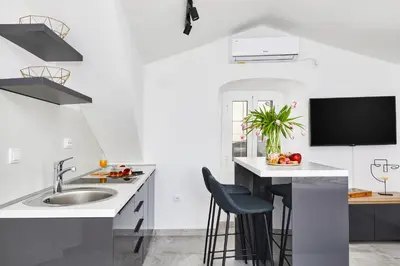 a white kitchen with a sink and a tv at Old Town Casa Dameo Apartments in Kotor