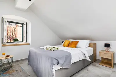 a bedroom with a bed with two dogs laying on it at Old Town Casa Dameo Apartments in Kotor