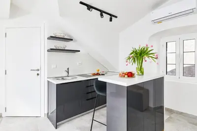 a kitchen with white walls and a black and white island at Old Town Casa Dameo Apartments in Kotor