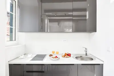 a white kitchen with a sink and a bowl of fruit at Old Town Casa Dameo Apartments in Kotor