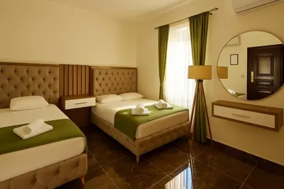 a hotel room with two beds and a mirror at Apartmani Enydoo in Ulcinj