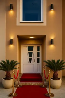 a front door with a red carpet and two plants at Apartmani Enydoo in Ulcinj