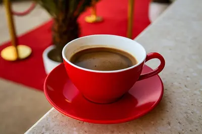 a red cup of coffee sitting on a table at Apartmani Enydoo in Ulcinj