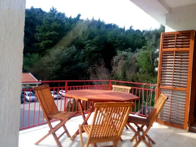 a wooden table and chairs on a balcony at Apartments Almaja Villa in Petrovac na Moru