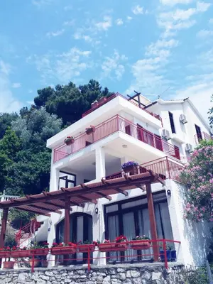 a large white building with a balcony and flowers at Apartments Almaja Villa in Petrovac na Moru