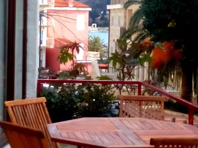 a wooden table and chairs on a balcony at Apartments Almaja Villa in Petrovac na Moru