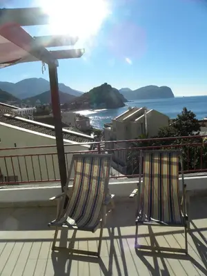 two chairs sitting on a balcony overlooking the ocean at Apartments Almaja Villa in Petrovac na Moru