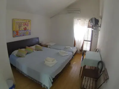a bedroom with a large bed and a window with at Apartments Almaja Villa in Petrovac na Moru