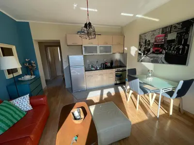a living room with a couch a table and a kitchen at Downtown Apartment in Kotor