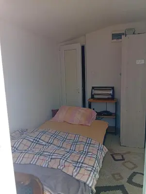 a small bedroom with a bed and a table at Monte room in Podgorica