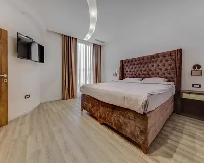 a bedroom with a large bed and a flat screen tv at Villa Una in Kotor