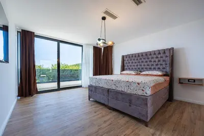 a bedroom with a bed and a large window at Villa Una in Kotor
