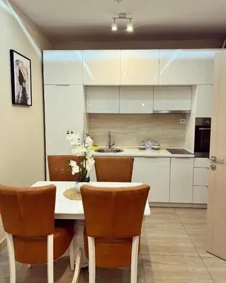a kitchen with white cabinets and a table and chairs at Nevenka in Bar