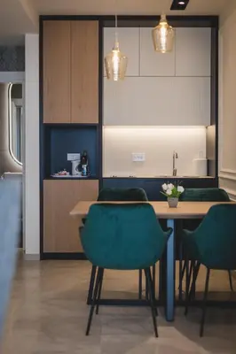 a kitchen with a wooden table and green chairs at Kalamper Apartments in Dobra Voda