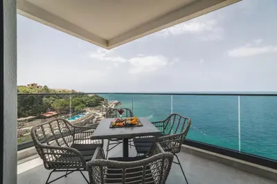 a balcony with a table and chairs and the ocean at Kalamper Apartments in Dobra Voda