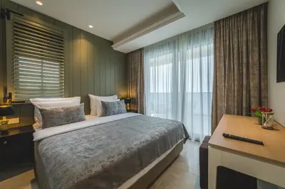 a bedroom with a bed and a desk and a window at Kalamper Apartments in Dobra Voda
