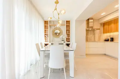 a dining room with a white table and white chairs at Kotor Lux apartments and rooms in Kotor