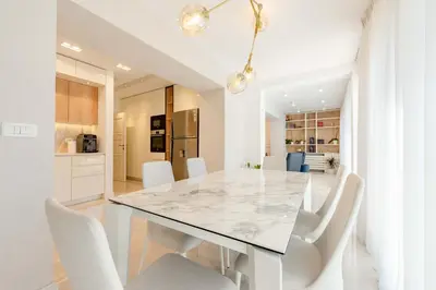 a white dining room with a marble table and white chairs at Kotor Lux apartments and rooms in Kotor