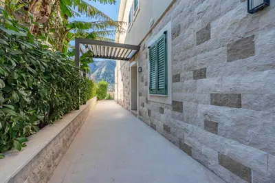 a hallway of a stone building with a green window at Kotor Lux apartments and rooms in Kotor