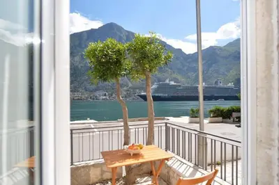 a balcony with a table and a view of the water at Cosy front line apt with sea access at your door step in Kotor