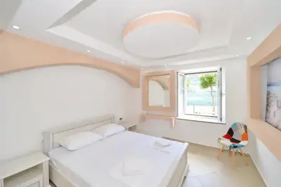 a bedroom with a large bed and a window at Cosy front line apt with sea access at your door step in Kotor