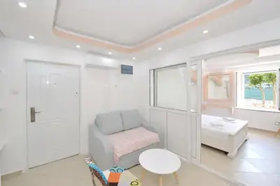 a white room with a chair and a table at Cosy front line apt with sea access at your door step in Kotor