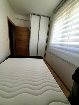 a bedroom with a large bed and a window at Aleksandar First Sea Line Apartment in Bar