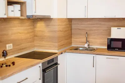 a kitchen with white cabinets and a sink at Montesun Fontana Apartments in Budva