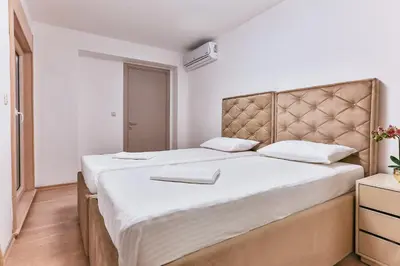 a bedroom with a large bed with white sheets at Montesun Fontana Apartments in Budva