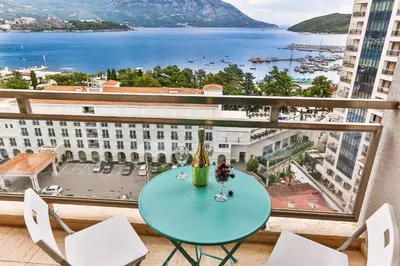 a table on a balcony with a view of the water at Montesun Fontana Apartments in Budva