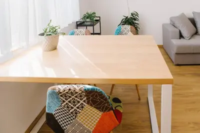 a wooden table in a living room with chairs at MILLENNIUM bridge cozy apartment TOP location in Podgorica