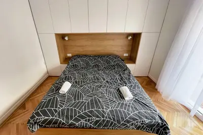 a bed in a small room with a bedskirtspectspectspectspects at MILLENNIUM bridge cozy apartment TOP location in Podgorica