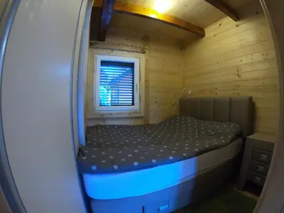 a small room with a bed in a wooden cabin at Mery Ada House in Ulcinj