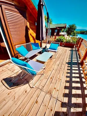 two lounge chairs and an umbrella on a wooden deck at Mery Ada House in Ulcinj