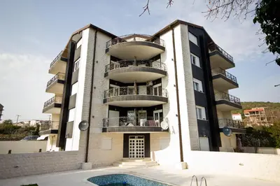 a building with a swimming pool in front of it at Lux Apartment 