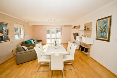 a living room with a table and chairs and a couch at Lux Apartment 