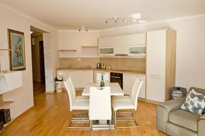 a kitchen and living room with a table and chairs at Lux Apartment 