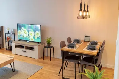 a dining room with a table and a television at Les appartements Privés Bar in Bar